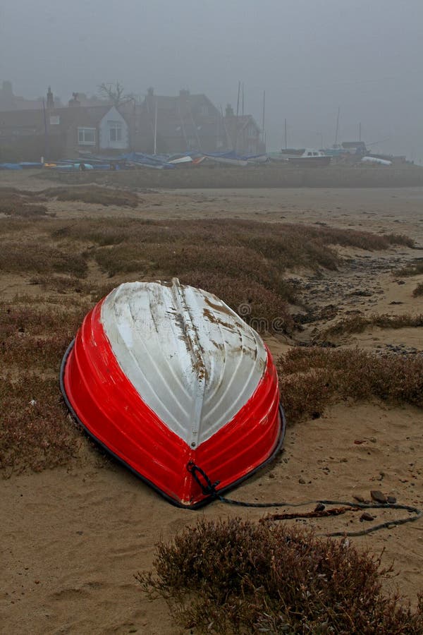 Early misty morning, tides out, red boat , Alnmouth beach, Northumberland. Early misty morning, tides out, red boat , Alnmouth beach, Northumberland