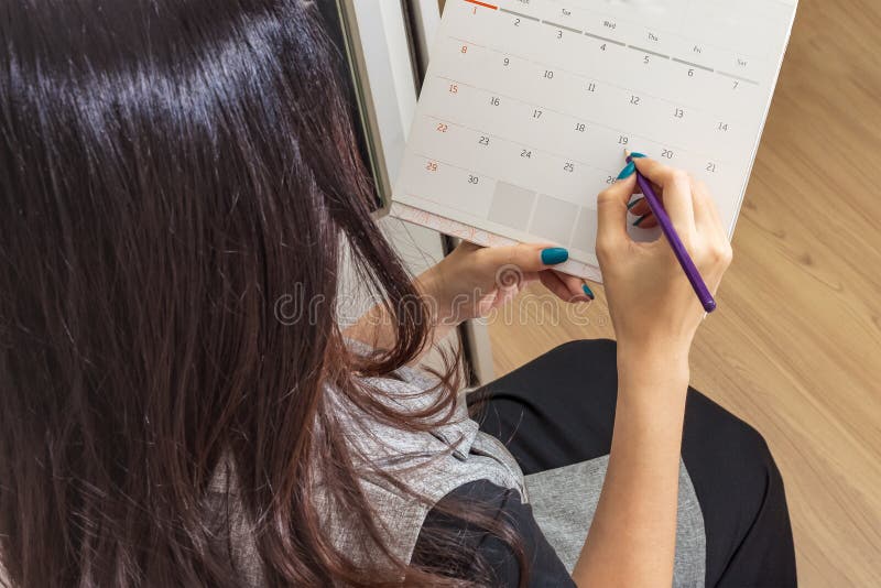Matita della tenuta della donna sul calendario per prendere appuntamento fotografia stock libera da diritti Matita della tenuta della donna sul calendario per prendere appuntamento fotografia stock libera da diritti