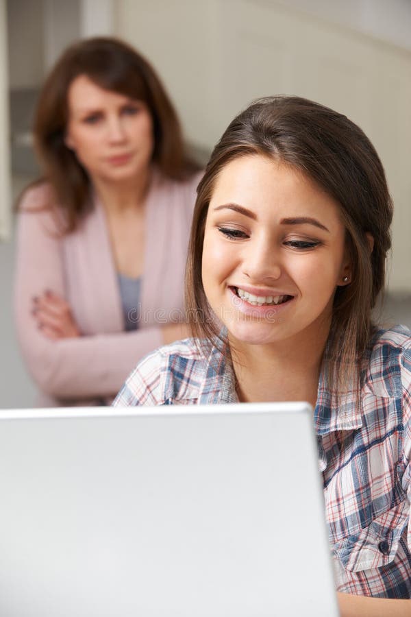 Matka Dotycząca O Nastoletniej córki Online aktywności zdjęcie stock Matka Dotycząca O Nastoletniej córki Online aktywności zdjęcie stock