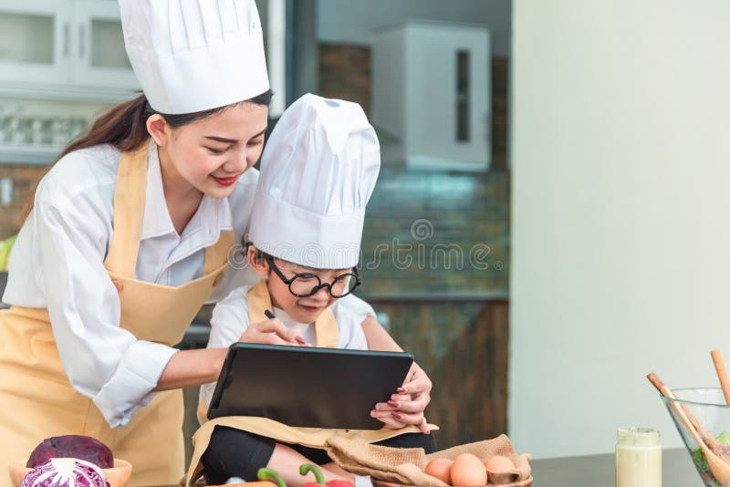 Matka, dziecko i komputerowy używamy, Wynaleziony karmowy menu fotografia stock Matka, dziecko i komputerowy używamy, Wynaleziony karmowy menu fotografia stock