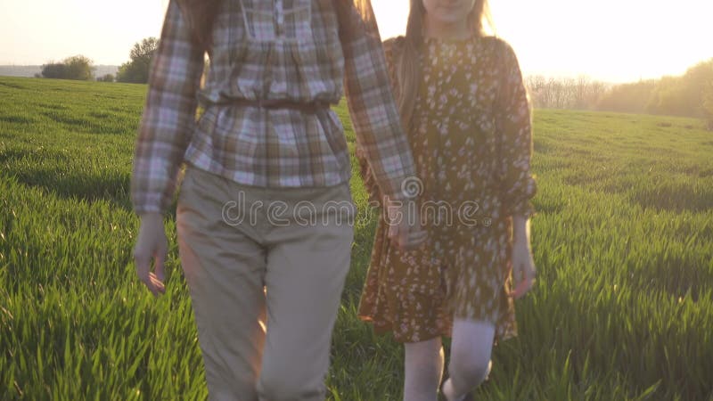 Matka i córka stoją na zielonym polu wieczorowym