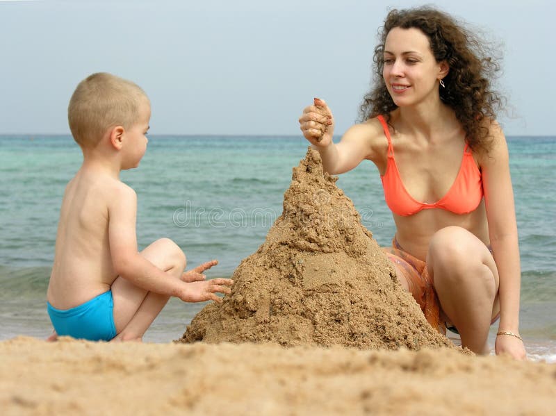 Mother with son play with sand on beach. Mother with son play with sand on beach