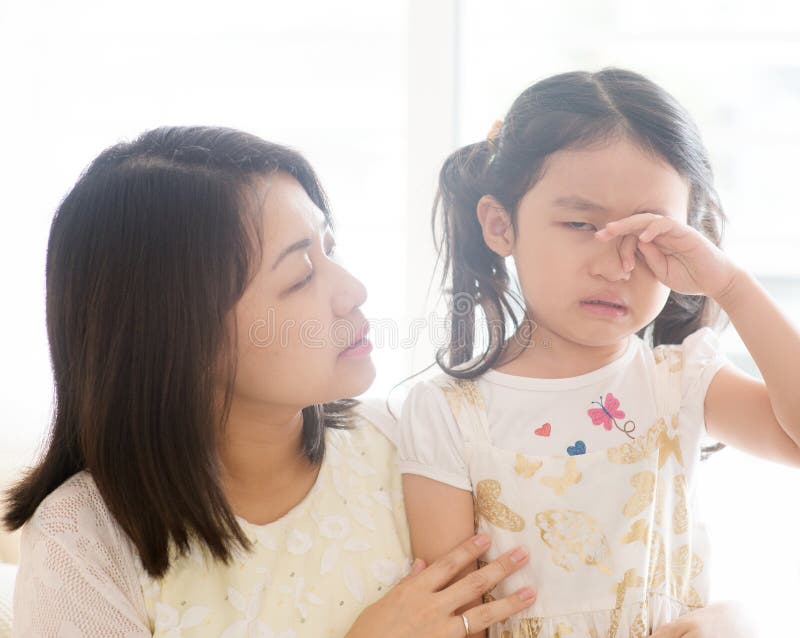 Mother comforting crying daughter. Asian family at home, living lifestyle indoors. Mother comforting crying daughter. Asian family at home, living lifestyle indoors.