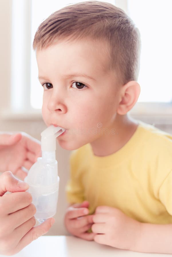 Matka taktuje bronchit w dziecku z nebulizer zdjęcie stock Matka taktuje bronchit w dziecku z nebulizer zdjęcie stock