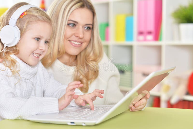 Matka z małą córką korzystająca z nowoczesnego notebooka w domu zdjęcie stock
