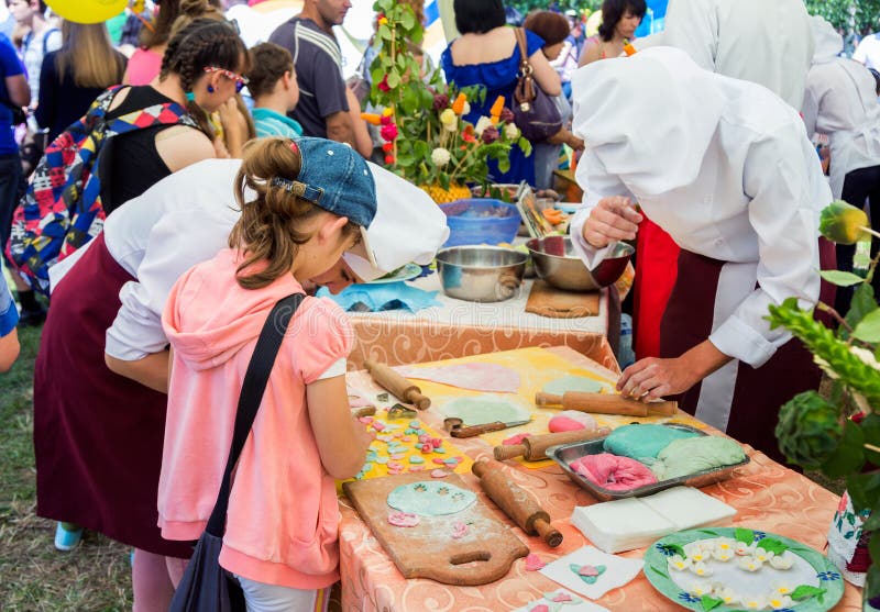 Zaporizhia/Ukraine- June 5, 2016: girl participating in pastry cooking workshop, learning to make colorful paste decorations, during charity family festival organized in regions with most quantity of refugees from Donetsk area, occasioned with International Children`s Day. Zaporizhia/Ukraine- June 5, 2016: girl participating in pastry cooking workshop, learning to make colorful paste decorations, during charity family festival organized in regions with most quantity of refugees from Donetsk area, occasioned with International Children`s Day