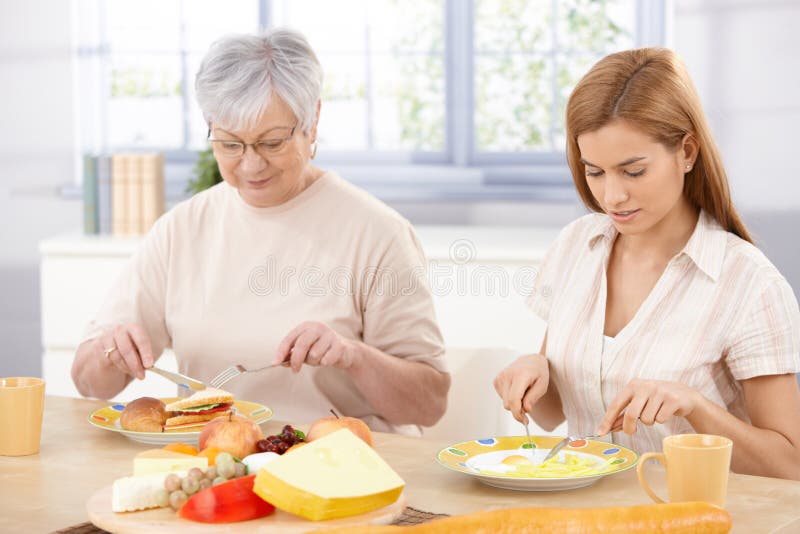 Matriz e filha que têm o almoço em casa imagens de stock Matriz e filha que têm o almoço em casa imagens de stock