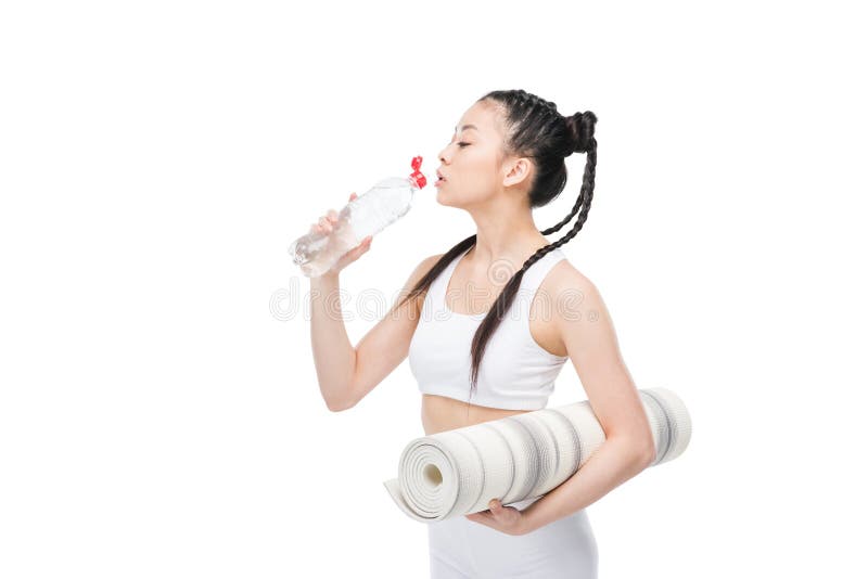 Matt hållande yoga för ung asiatisk kvinna och dricksvatten från flaskan