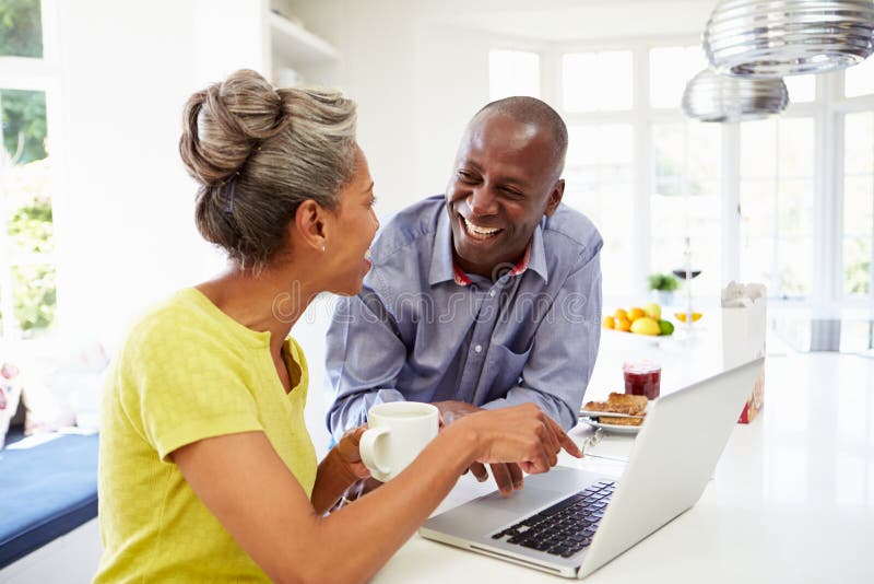 Mature African American Couple Using Laptop At Bre stock photography Mature African American Couple Using Laptop At Bre stock photography