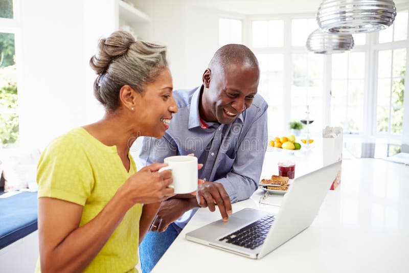 Mature African American Couple Using Laptop At Bre