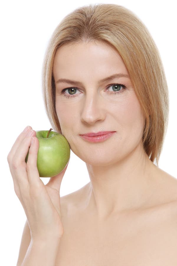 Portrait of beautiful mature woman with clear skin and green apple in her hand, on white background. Portrait of beautiful mature woman with clear skin and green apple in her hand, on white background