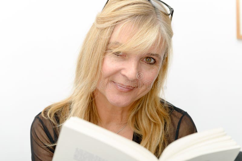 Mature blond woman reading a book