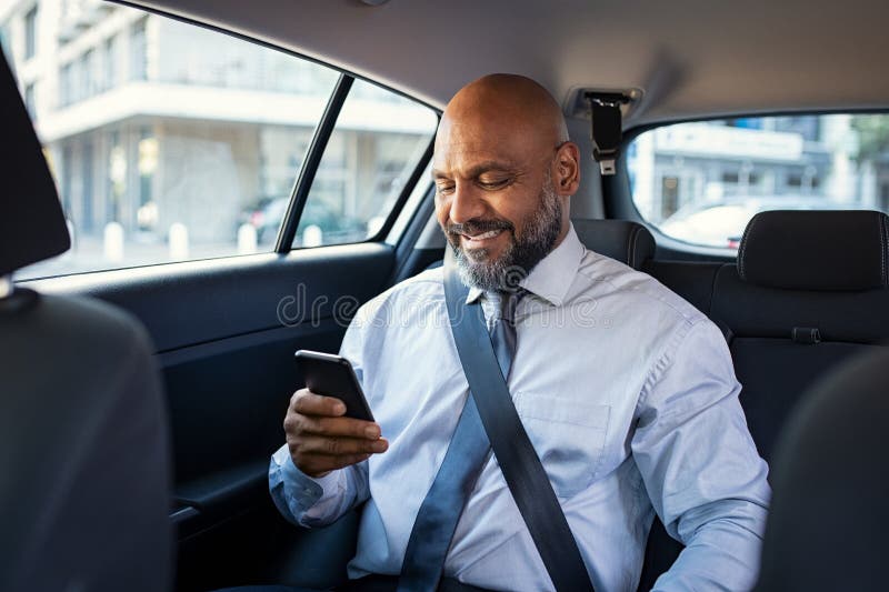 Mature business man using phone in car