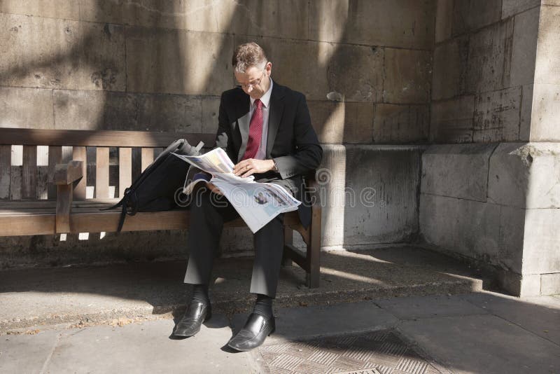 Mature Businessman Sitting on Bench Reading Newspaper Stock Image ...