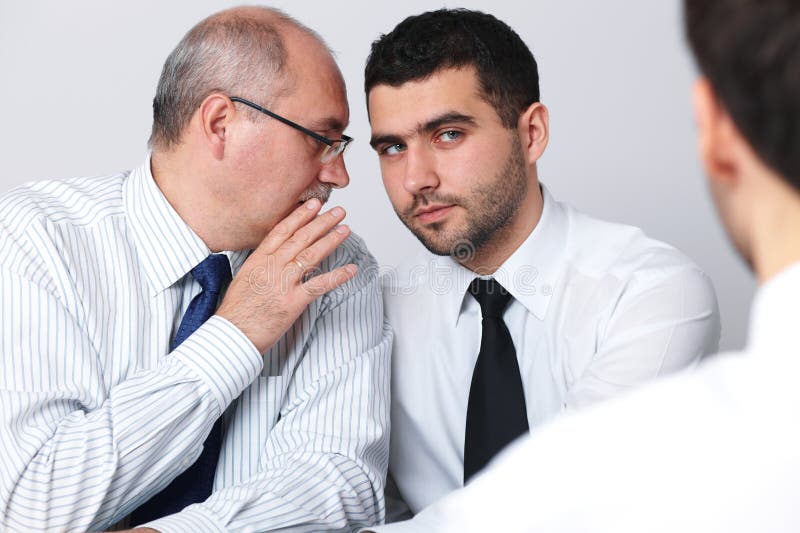 Mature businessman whisper something to colleague