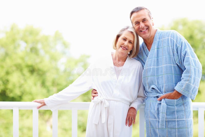 Mature Couple In Bathrobes Enjoying Their Retirement Vacation Cute Mature Couple In Bathrobes