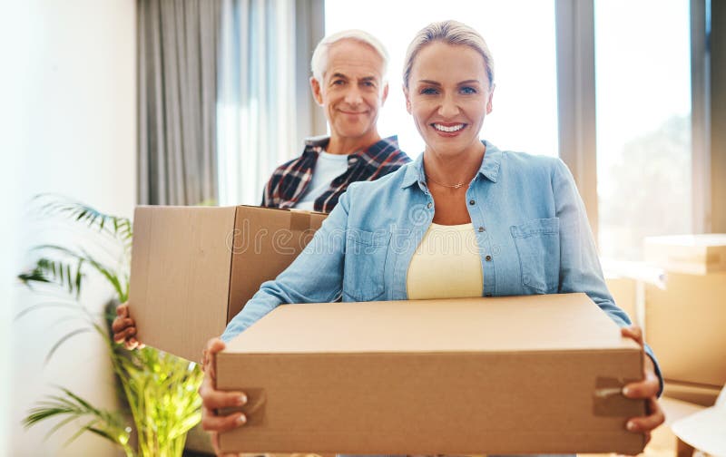 Mature couple, box and portrait in home for moving, mortgage or package in morning. Man, woman and cardboard and stock image