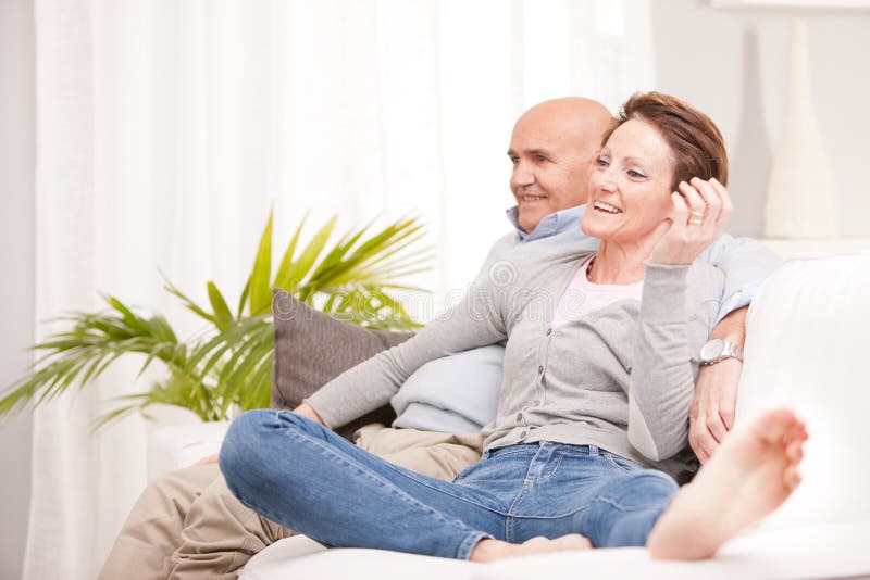 Mature woman watching through a window stock photo