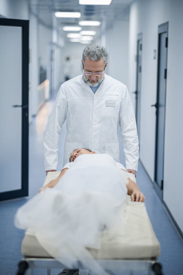 A Mature Doctor Carrying the Gurney with a Patient Stock Image Image of woman, grayhaired