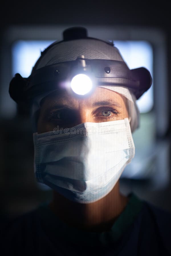 Mature female surgeon standing with surgical head lamp in hospital royalty free stock images Mature female surgeon standing with surgical head lamp in hospital royalty free stock images