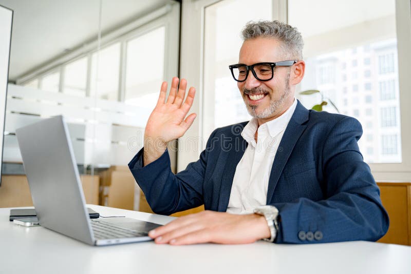 Mature gray-haired 60 businessman using laptop for video connection royalty free stock photo