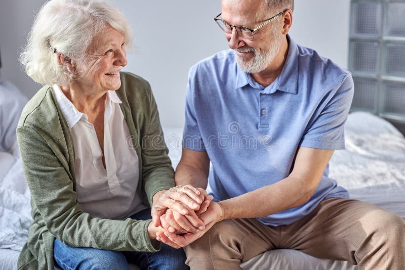 mature gray-haired couple holding each other&#x27;s hands in love royalty free stock image