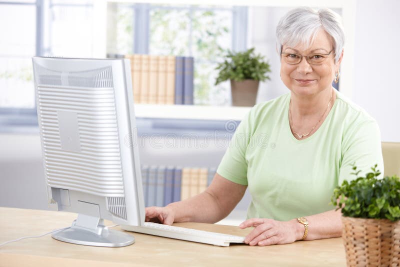 Mature lady with computer smiling stock photography Mature lady with computer smiling stock photography