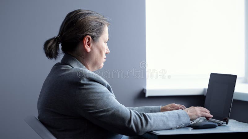 Mature Woman Searches Information on Modern Laptop in Flat Stock Video