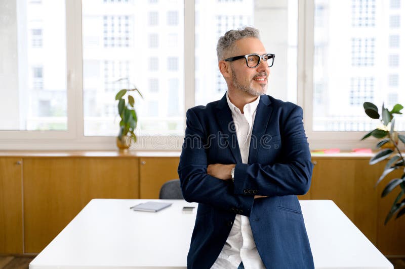 Mature male employee standing with arms crossed royalty free stock photos