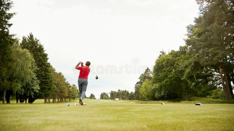 Mature Male Golfer Hitting Tee Shot Along Fairway With Driver