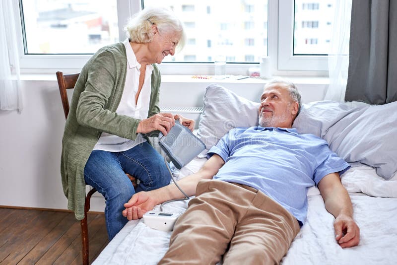 senior male patient at hospital with worried wife sitting with him stock photography