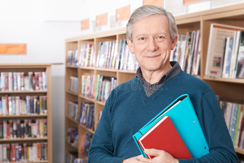 Portrait Of Mature Male Student Studying In Library. Standing file folder stock images, royalty-free photos and pictures