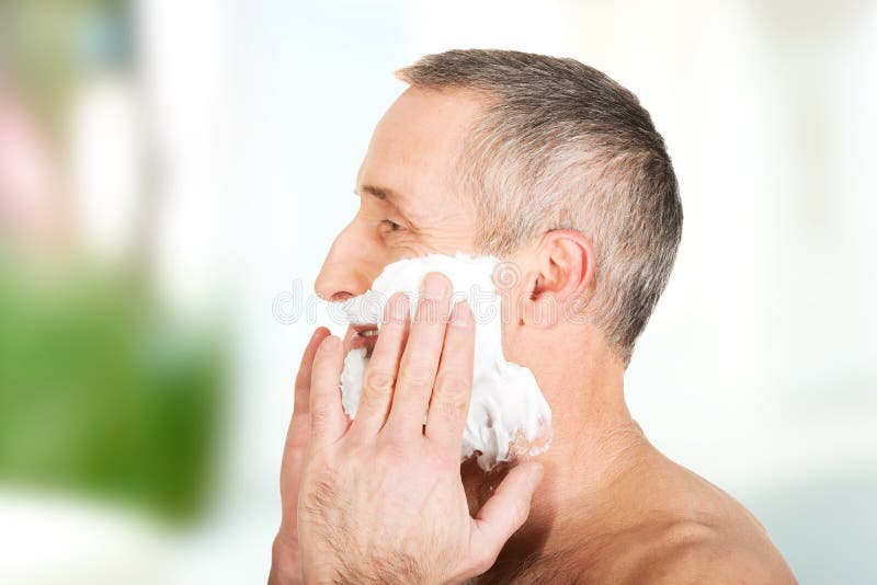 Mature man applying shaving foam stock photo