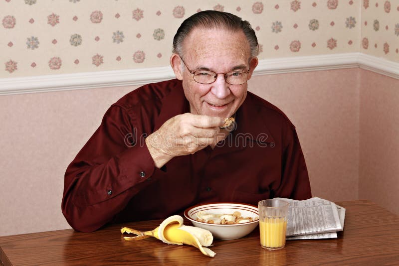 Mature man eating breakfast