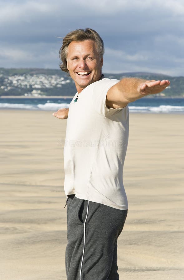 Mature man laughing on beach.