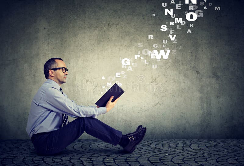 Mature serious man reading a book with alphabet letters coming out of the book royalty free stock images Mature serious man reading a book with alphabet letters coming out of the book royalty free stock images