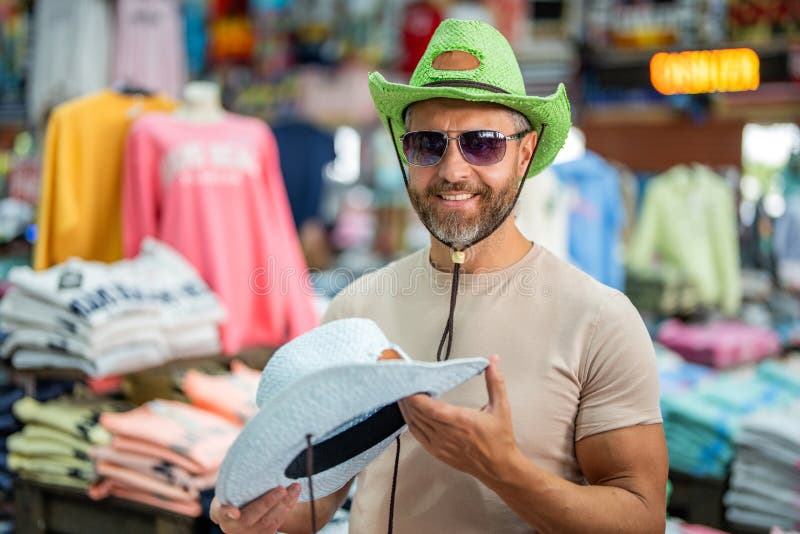 Mature man som väljer hat. Lager för manliga tillbehör. Trendy-modebutik. Handsome man som försöker på hatt. Hat, manlig modebutik royaltyfria bilder