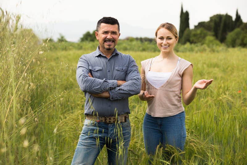 Mature man and woman standing in wheat field