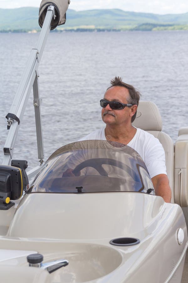 Mature men driving a pontoon boat on a lake