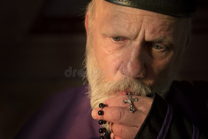 Mature priest, praying with rosary beads royalty free stock photo Mature priest, praying with rosary beads royalty free stock photo