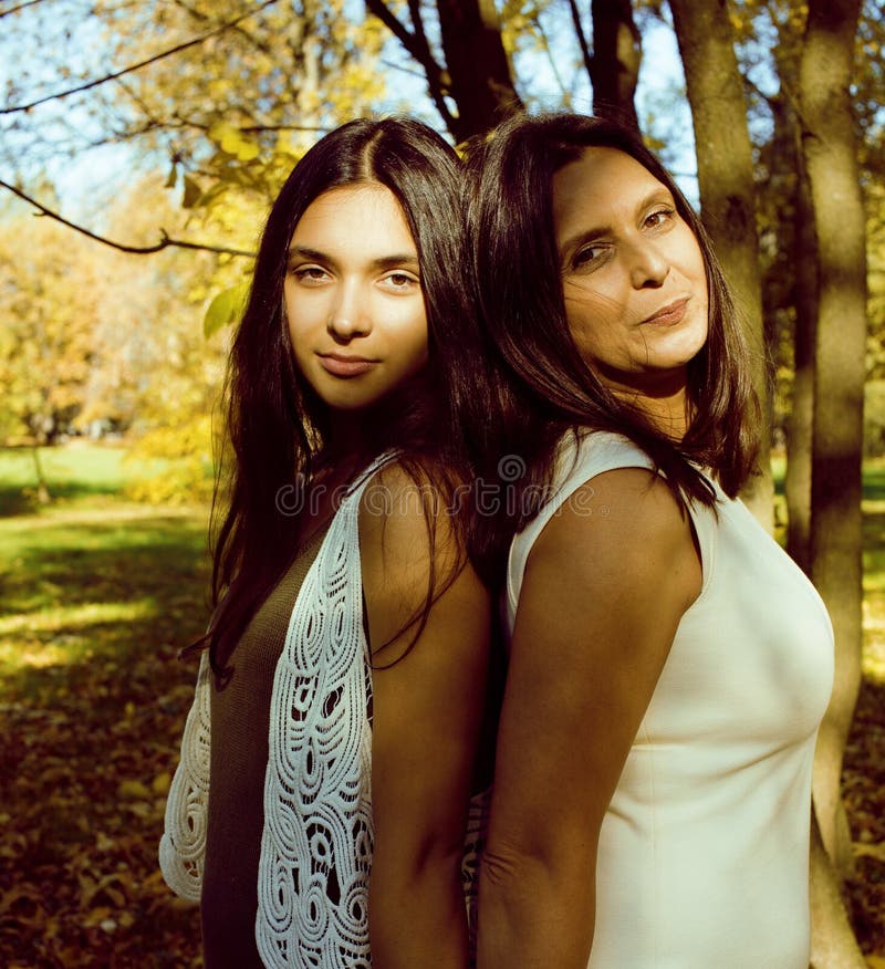 Mature real mother with daughter outside autumn fall in park. 