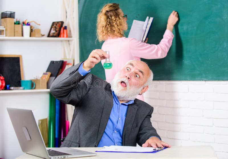 Mature Teacher With Beaker Flask. Biology Lesson. Science And Biotechnology Research Concept. Education Of Chemistry