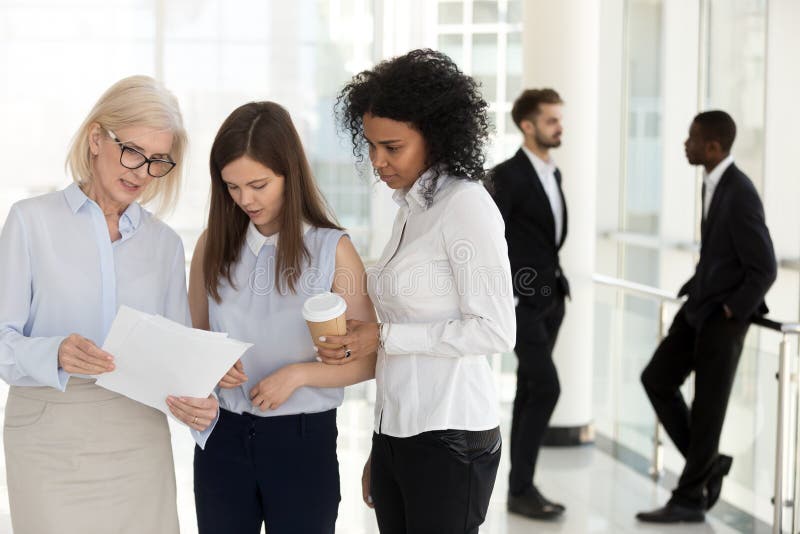 Mature team leader and young employees discussing paperwork in o royalty free stock photos Mature team leader and young employees discussing paperwork in o royalty free stock photos