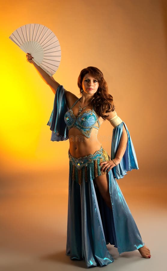 Mature woman in belly dance with fan. 