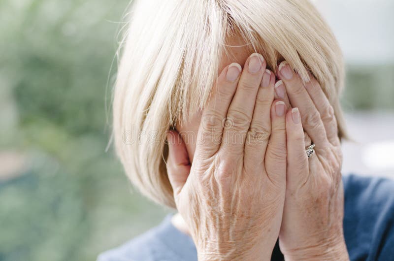Mature woman covering her face with her hands. royalty free stock photography