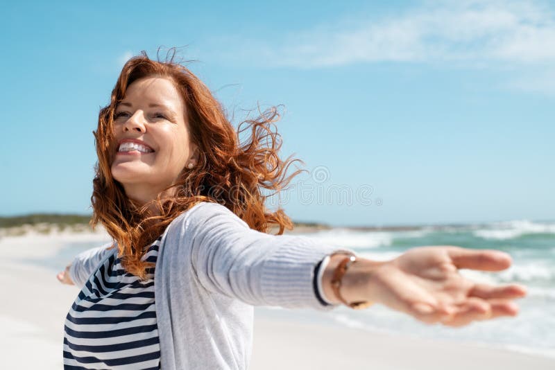 Mature woman enjoy breeze at beach