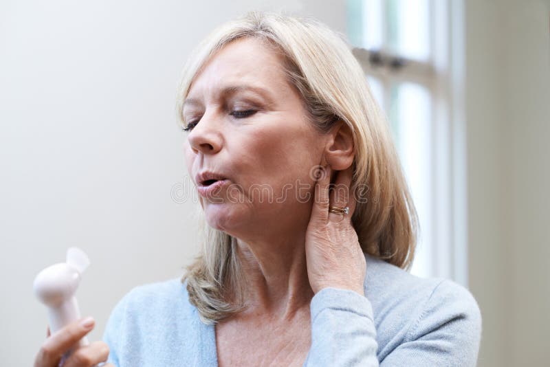 Mature Woman With Fan Experiencing Hot Flush From Menopause. Mature Woman With Fan Experiencing Hot Flush From Menopause