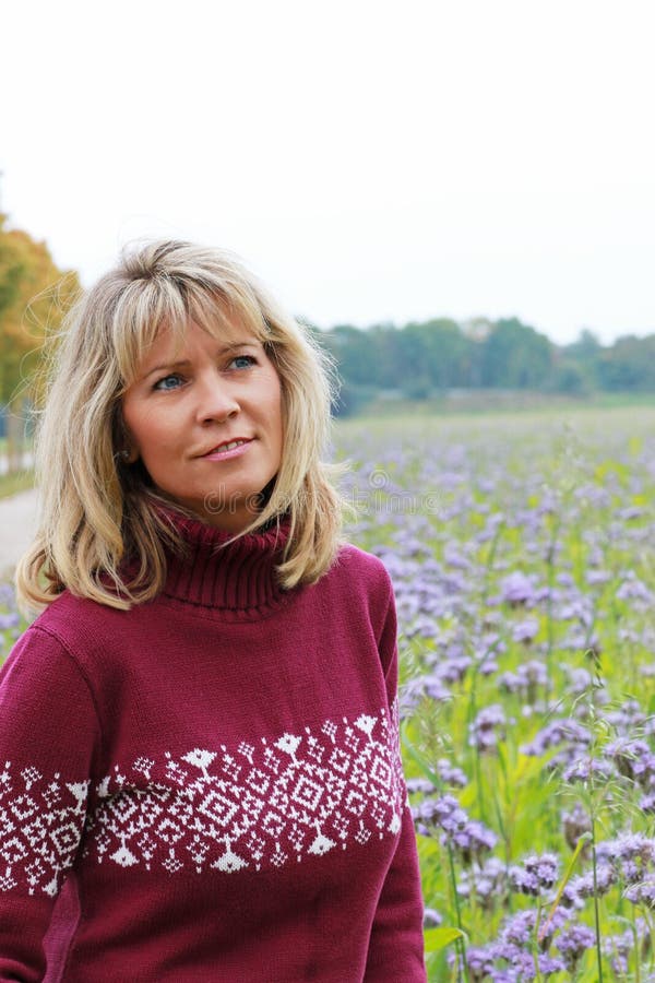 Mature woman in front of a lilac flower field stock images Mature woman in front of a lilac flower field stock images
