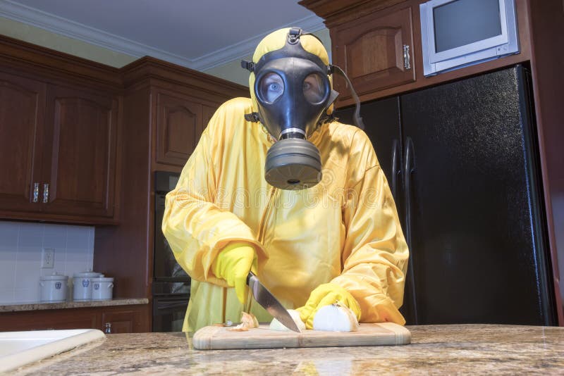 Mature woman in Haz Mat suit chopping onions