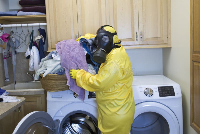 Mature woman in Haz Mat suit sorting laundry